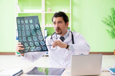 Doktor radyoloji uzmanı hastanede röntgen taramasına bakıyor.