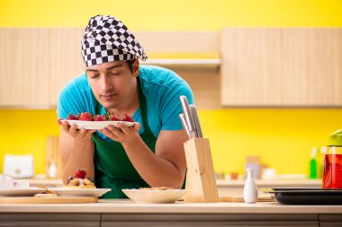 Adam evde pasta hazırlıyor.