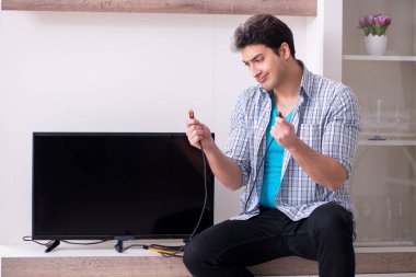 Bozuk televizyonu tamir etmeye çalışan adam