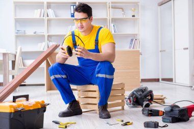 Genç müteahhit ofiste tamirat yapıyor. 