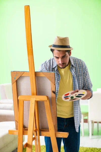 Young male artist working on new painting in his studio — Stock Photo, Image