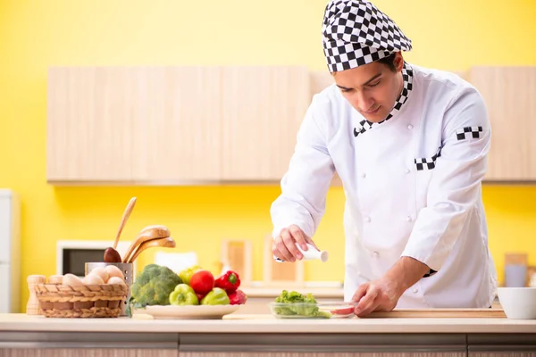 Young professional cook preparing salad at home — Stock Photo, Image