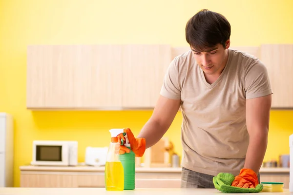 Svobodný muž úklid kuchyně doma — Stock fotografie