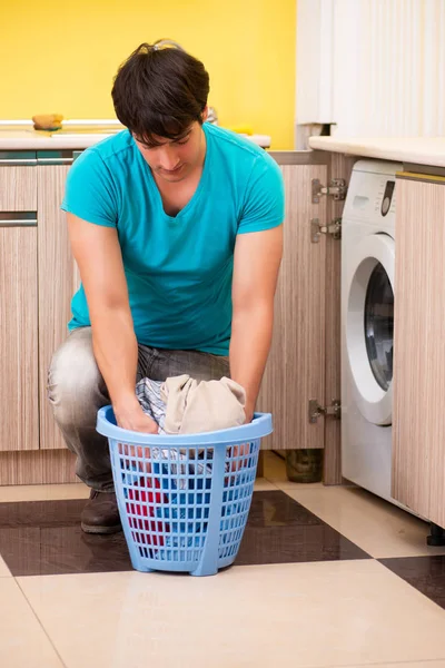 Jonge man doet de was thuis — Stockfoto