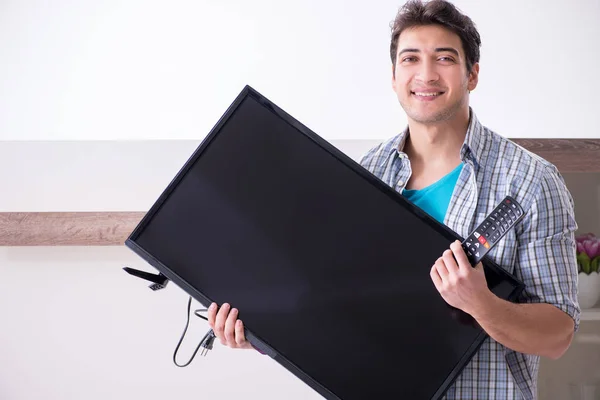 Mann versucht kaputten Fernseher zu reparieren — Stockfoto