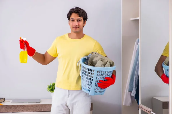 Joven hombre guapo limpieza en el dormitorio — Foto de Stock