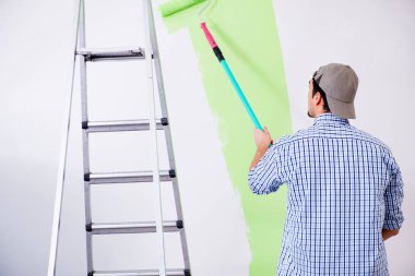 Genç ressam evde tadilat yapıyor. 