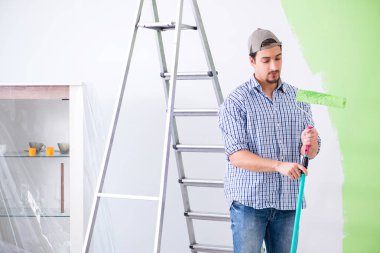 Genç ressam evde tadilat yapıyor. 