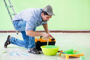 Genç adam evini yeniliyor. 