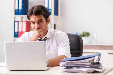 Genç yakışıklı işadamı ofiste çalışıyor.