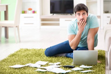 Genç adam kişisel finans ve faturalarla boğuşuyor.