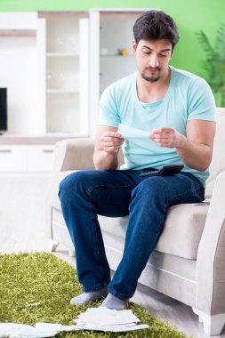 Genç adam kişisel finans ve faturalarla boğuşuyor.