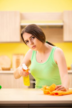 Genç, güzel bir kadın mutfakta cilalama masası. 