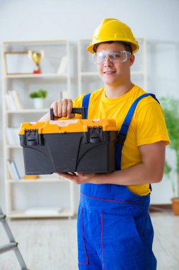 Genç müteahhit ofiste tamirat yapıyor. 