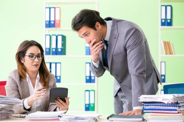 Ofiste çalışan iki finans uzmanı.