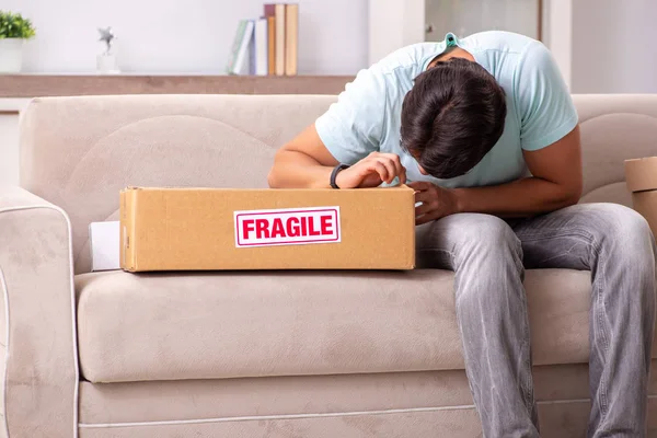 Hombre abriendo frágil paquete ordenado de internet —  Fotos de Stock