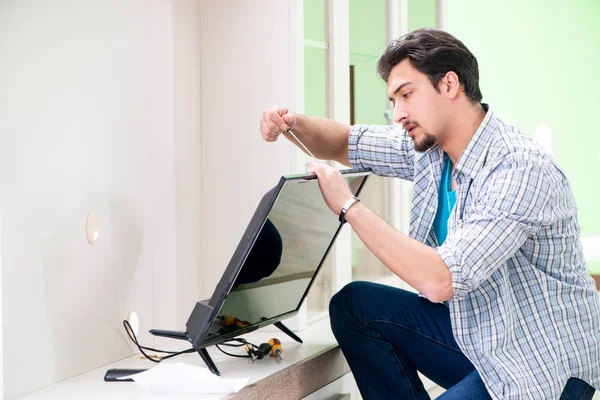 Young man husband repairing tv at home — Stock Photo, Image