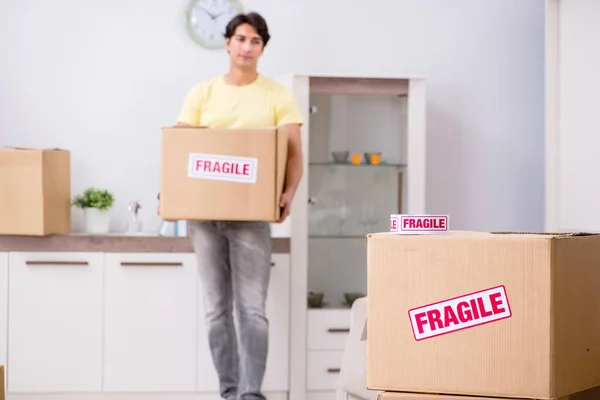 Hombre mudanza casa y reubicación con elementos frágiles —  Fotos de Stock