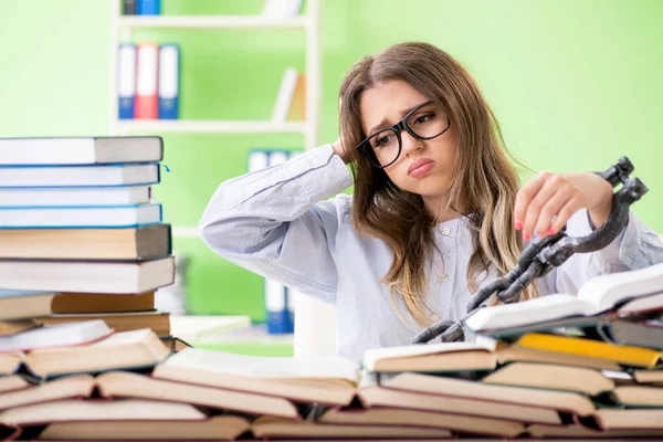 Jovem estudante acorrentada à mesa e se preparando para exames — Fotografia de Stock