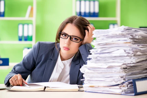 Junge Mitarbeiterin mit laufendem Papierkram beschäftigt — Stockfoto