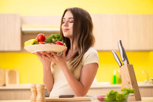 若いです女性準備サラダで自宅でキッチン — ストック写真