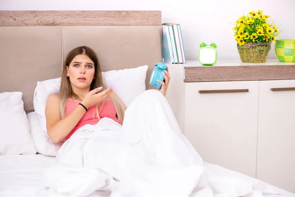 Mujer joven despertando por la mañana en la cama — Foto de Stock