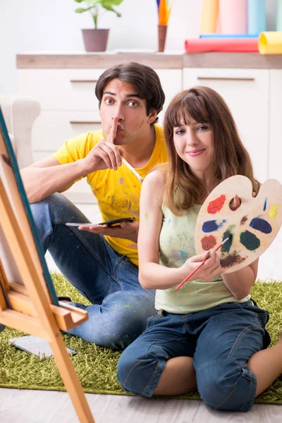 Fiatal pár élvezi a festést otthon — Stock Fotó