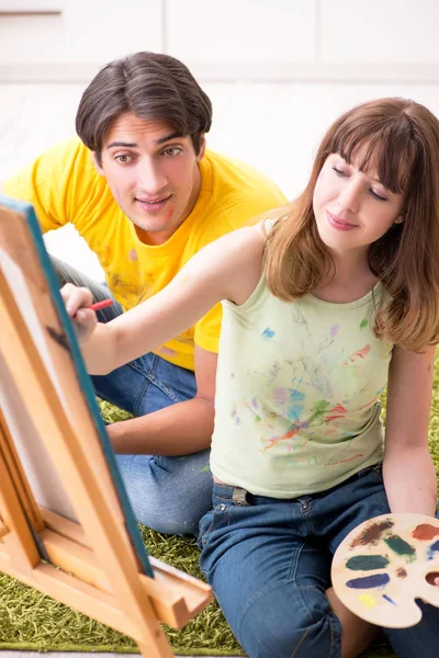 Jovem casal curtindo pintura em casa — Fotografia de Stock