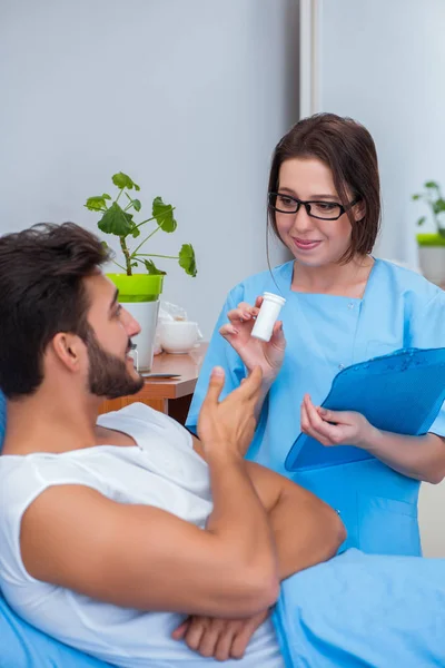 Woman doctor examining male patient in hospital — Stock Photo, Image