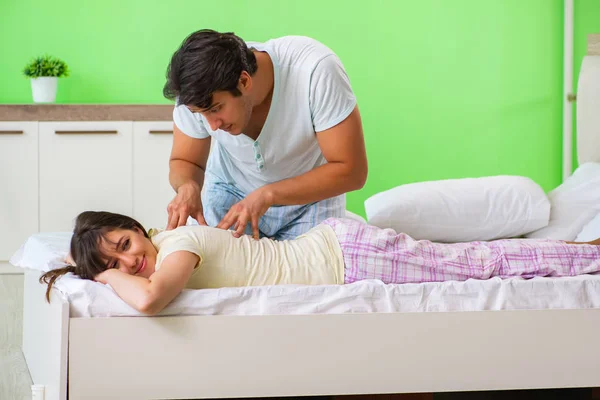 Mężczyzna robi masaż żonie w sypialni — Zdjęcie stockowe