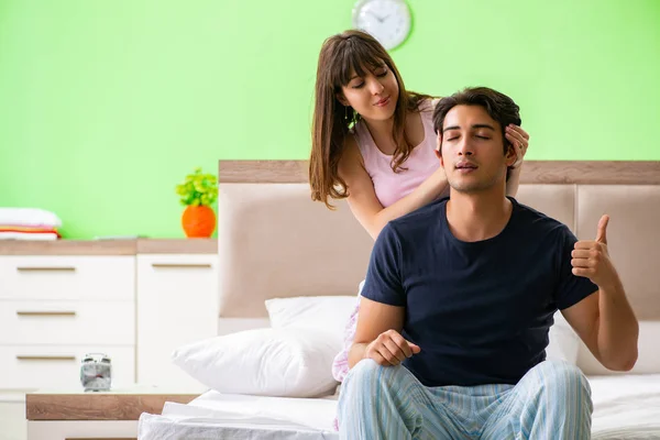 Vrouw doet massage naar haar man in slaapkamer — Stockfoto