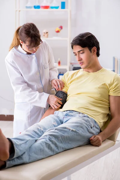 患者の血圧をチェックする若い医師 — ストック写真
