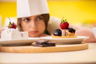 Genç aşçı mutfakta kek pişiriyor.