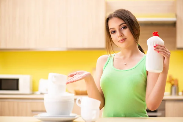 Mujer joven limpiando y lavando platos en la cocina —  Fotos de Stock