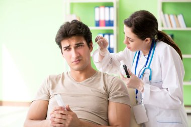 Tıbbi muayene sırasında kadın doktor hastaların kulaklarını kontrol ediyor. 