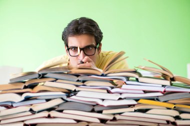 Sınavdan önce okumak için çok fazla kitabı olan öğrenci