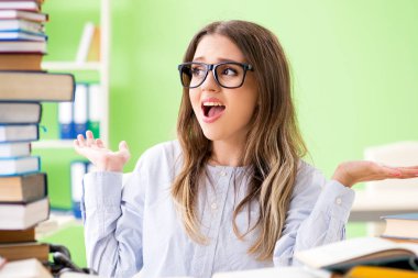 Sınavlara bir sürü kitapla hazırlanan genç kız öğrenci. 