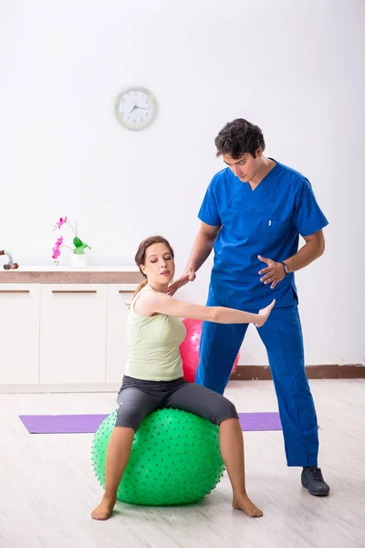 Instrutor de fitness ajudando desportista durante o exercício — Fotografia de Stock