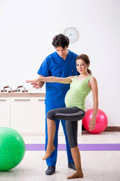 Pregnant woman doing physical exercies with instructor — Stock Photo, Image