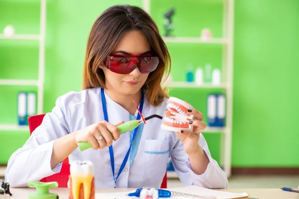 Diş implantı üzerinde çalışan kadın dişçi.