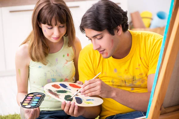 Jovem casal curtindo pintura em casa — Fotografia de Stock