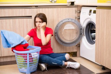 Evde çamaşır yıkayan bir kadın.