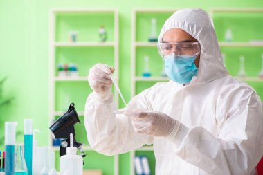 Laboratuvarda yeni bir deney üzerinde çalışan kimyager.