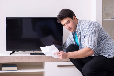 Bozuk televizyonu tamir etmeye çalışan adam
