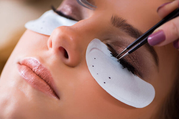 Young woman getting eyelash extension