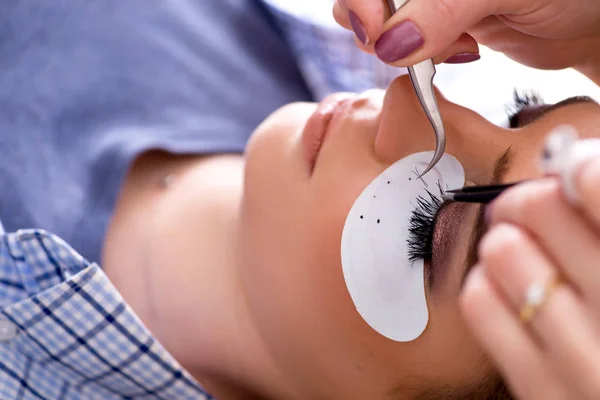 Mujer joven recibiendo extensión de pestañas — Foto de Stock