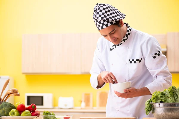 Joven cocinero profesional preparando ensalada en casa — Foto de Stock