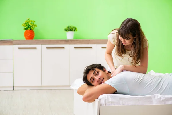 Donna che fa massaggio al marito in camera da letto — Foto Stock