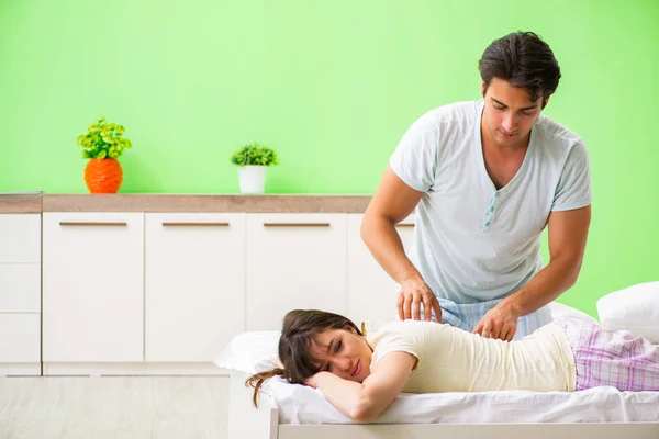 Mężczyzna robi masaż żonie w sypialni — Zdjęcie stockowe