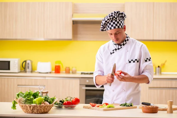 Joven cocinero profesional preparando ensalada en la cocina — Foto de Stock